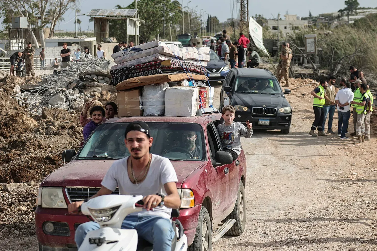  Güney Lübnan'dan yerinden edilmiş insanlar, Litani Nehri'nin güneyine ulaşmak için yıkılmış bir köprüden geçiyor (Reuters)