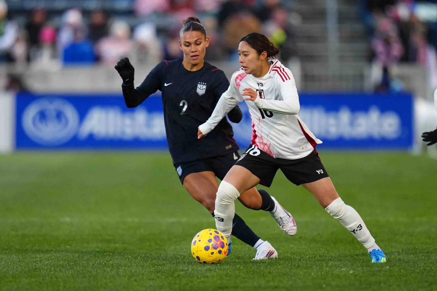 لاعبة وسط منتخب اليابان يوزوكي ياماموتو تسيطرعلى الكرة أمام مهاجمة منتخب الولايات المتحدة ترينيتي رودمان (أ.ب)