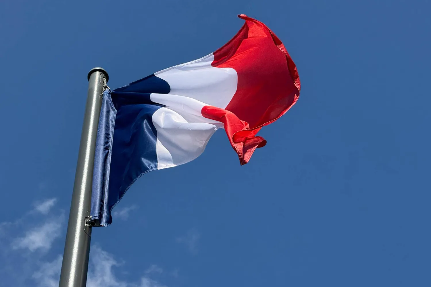 FILED - 08 August 2025, France, Paris: The French flag, also known as the tricolor, flies against a blue sky in central Paris. Photo: Rachel Sommer/dpa