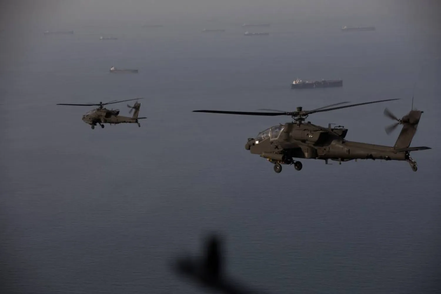 This handout photo released by US Central Command via their X account (@CENTCOM) on April 18, 2026 shows AH-64 Apaches flying above the Strait of Hormuz during a patrol on April 17, 2026. (US Central Command (CENTCOM) / AFP) 