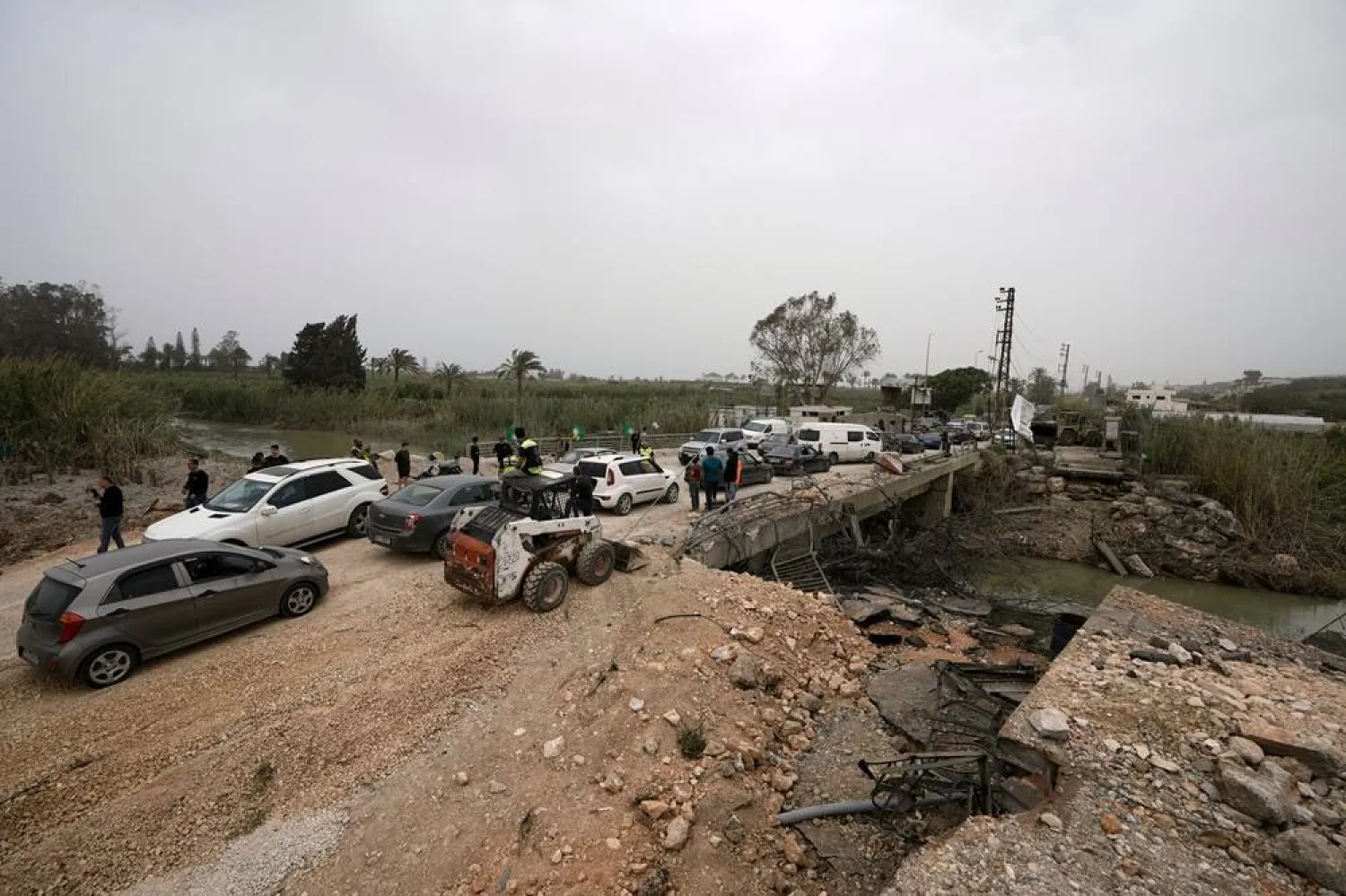 Displaced people cross a destroyed bridge which was hit few days ago in an Israeli airstrike, as they return to their villages on the second day of a ceasefire between Hezbollah and Israel in Qasmiyeh, near Tyre city, southern Lebanon, Saturday, April 18, 2026. (AP) 