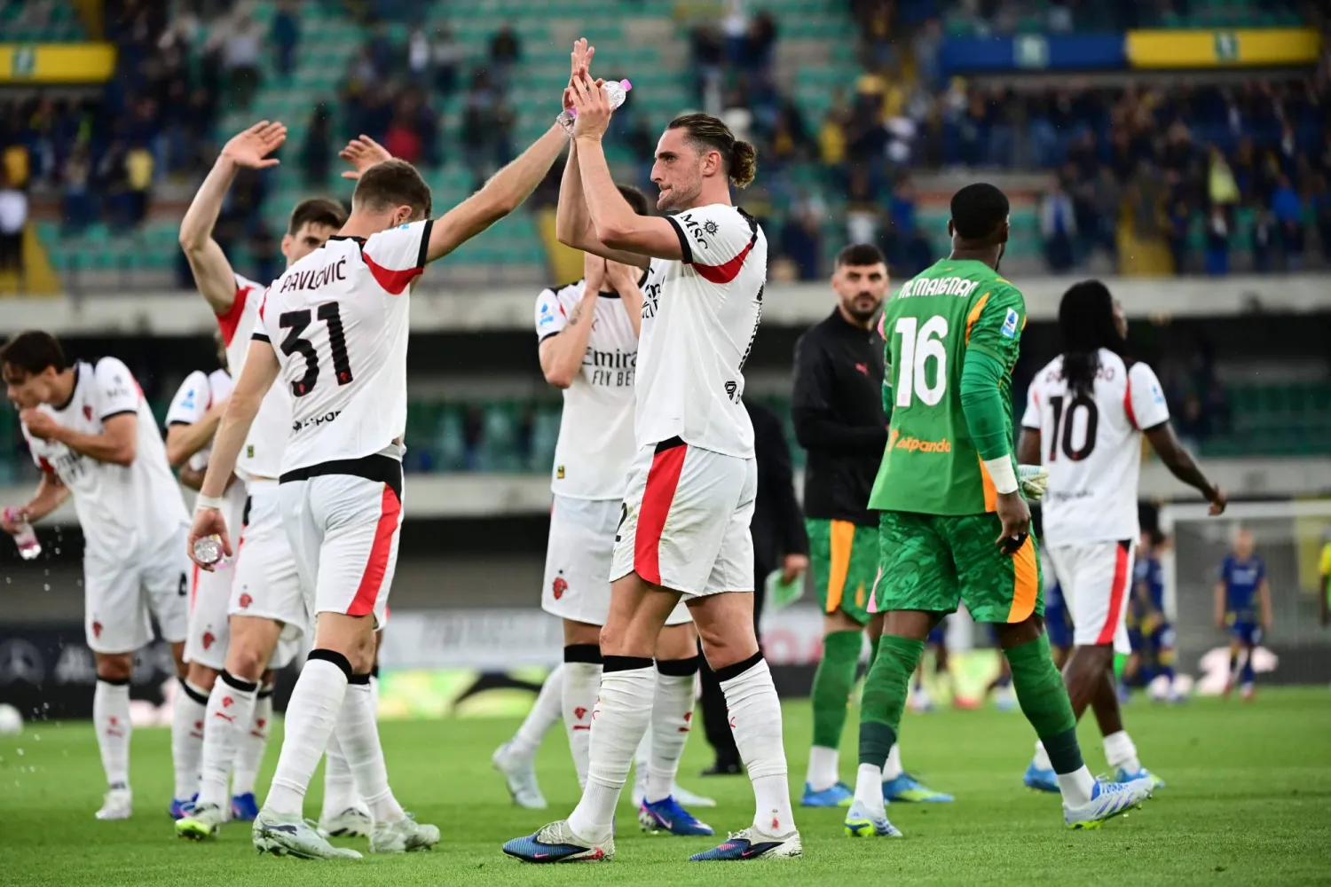 مدافع ميلان ستراهينيا بافلوفيتش ولاعب الوسط أدريان رابيو يحيّيان الجماهير عقب نهاية المباراة أمام هيلاس فيرونا (أ.ف.ب)