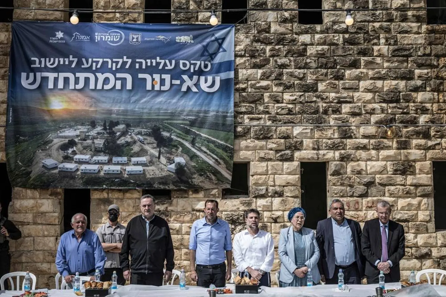 Israeli Defense Minister Israel Katz, (3rd-L), Yossi Dagan, Head of the Shomron Regional Council (4th-L), and Israel's far-right Finance Minister Bezalel Smotrich (4th-R) stand for the national anthem as they attend the resettlement ceremony of Sa-Nur, south of Jenin, in the Israeli-occupied West Bank on April 19, 2026. (AFP)