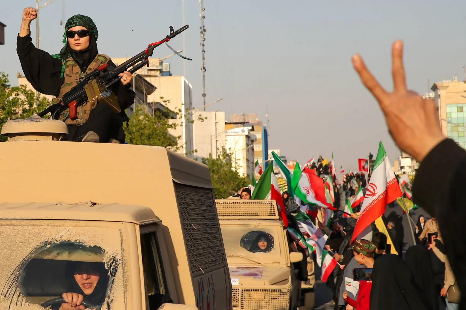 إيرانية تحمل سلاحاً خلال مسيرة في طهران الجمعة (د.ب.أ)