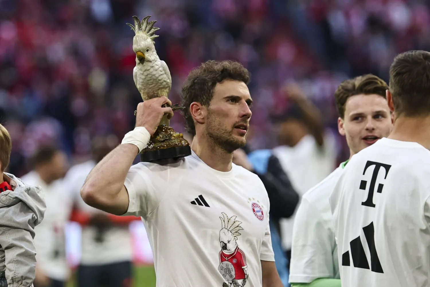 لاعب بايرن ميونيخ ليون غوريتسكا يحتفل ممسكاً بتمثال ببغاء الكوكاتو المصنوع من الخزف (أ.ف.ب)