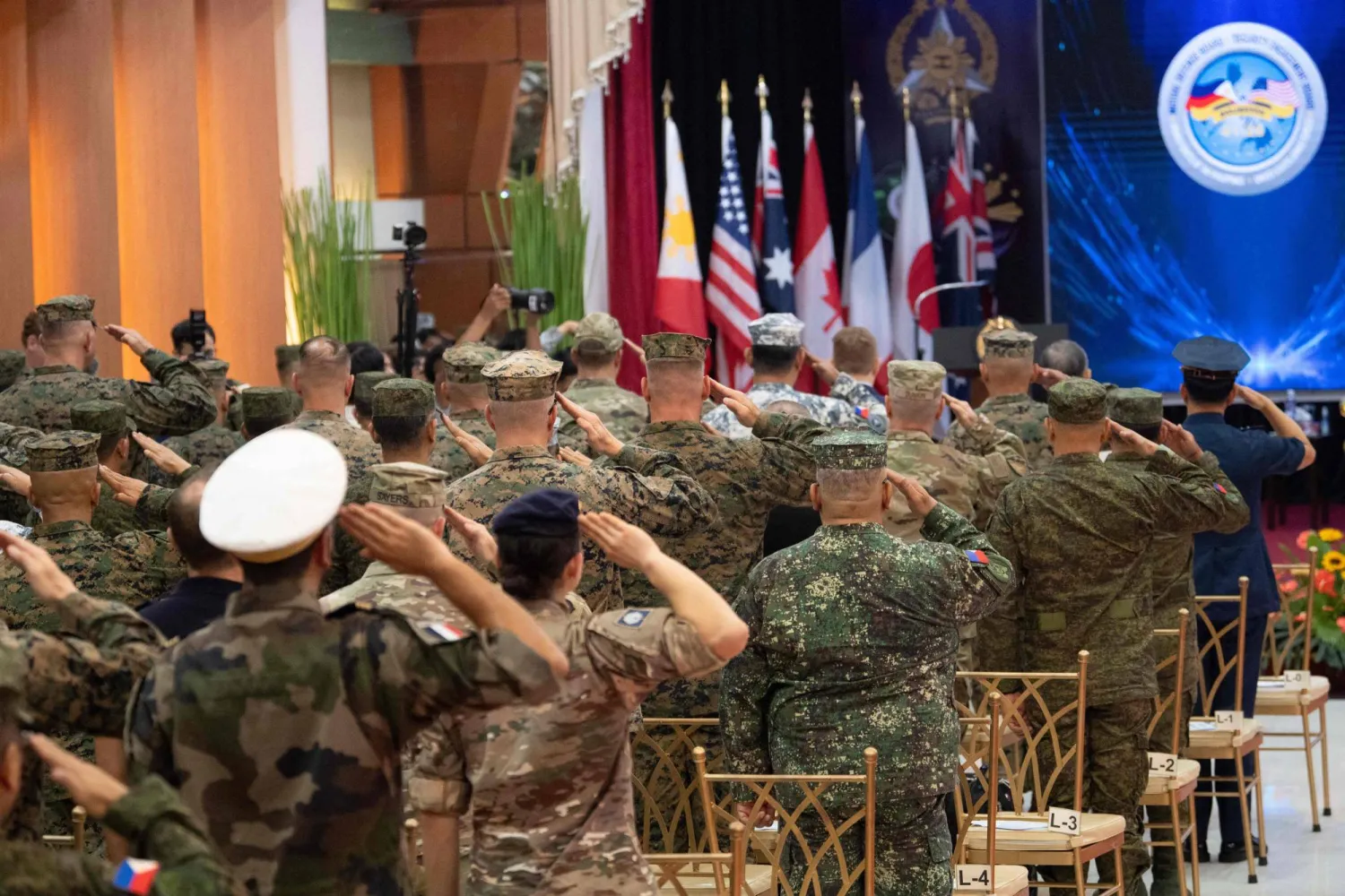 Philippine and US soldiers salute as their national anthems are played during the opening ceremony of the annual Balikatan joint military exercise at Camp Aguinaldo in Quezon city, suburban Manila on April 20, 2026. (AFP)
