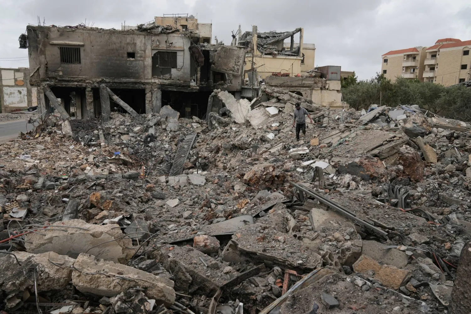 Mohammed Ameen walks on the rubble of a building destroyed in a previous Israeli airstrike during a ceasefire between Hezbollah and Israel in the Hosh neighborhood of Tyre, southern Lebanon, on Sunday, April 19, 2026. (AP)