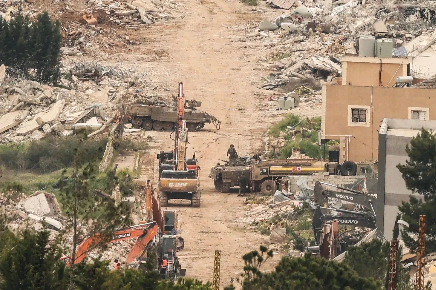 Israeli military vehicles and armored units in front of destroyed buildings in southern Lebanon on April 15. (AFP) 