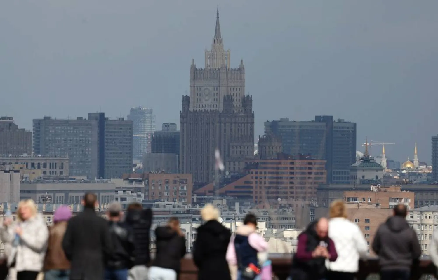 People visit the observation deck at Vorobyovy gory (Sparrow Hills) with the main building of the Ministry of Foreign Affairs of Russia in the background during a spring day in Moscow, Russia, 17 April 2026. (EPA)