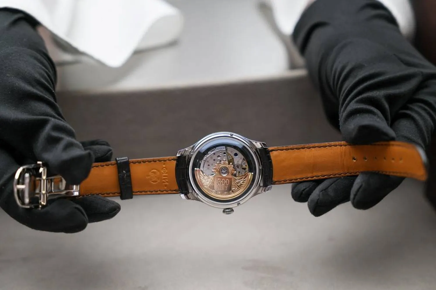 An employee demonstrates a watch at the Raketa Watch Factory in Peterhof, part of Saint Petersburg, Russia, April 1, 2026. (Reuters)
