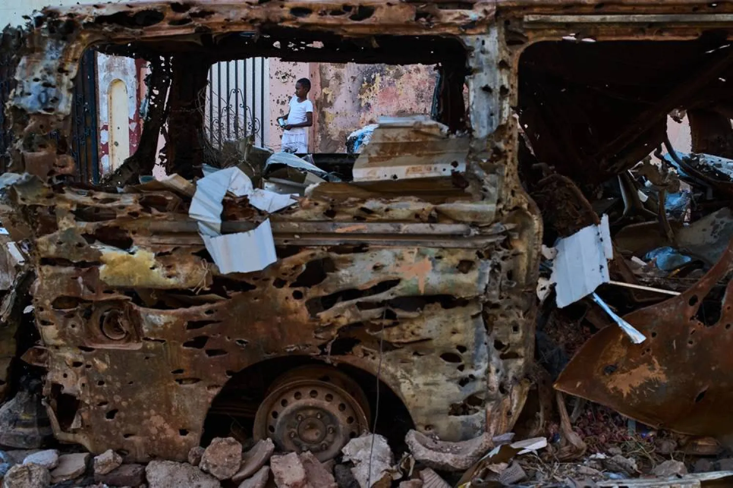  A boy is seen through the wreckage of a car in Omdurman, Sudan, on the outskirts of Khartoum, Friday, April 17, 2026. (AP) 