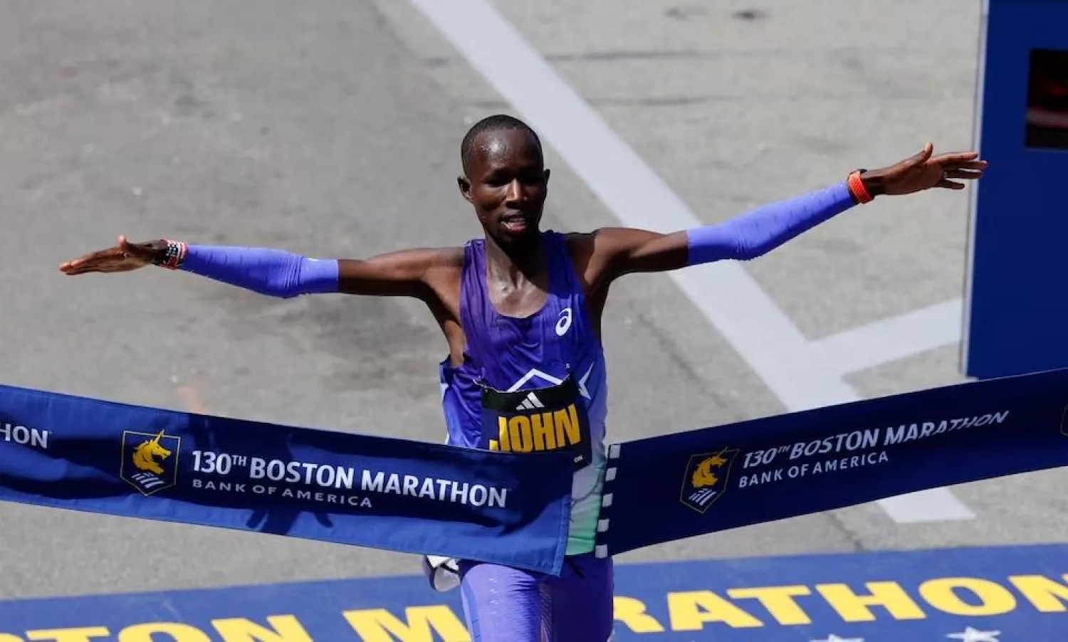 العداء الكيني جون كورير لحظة فوزه بماراثون بوسطن (رويترز)