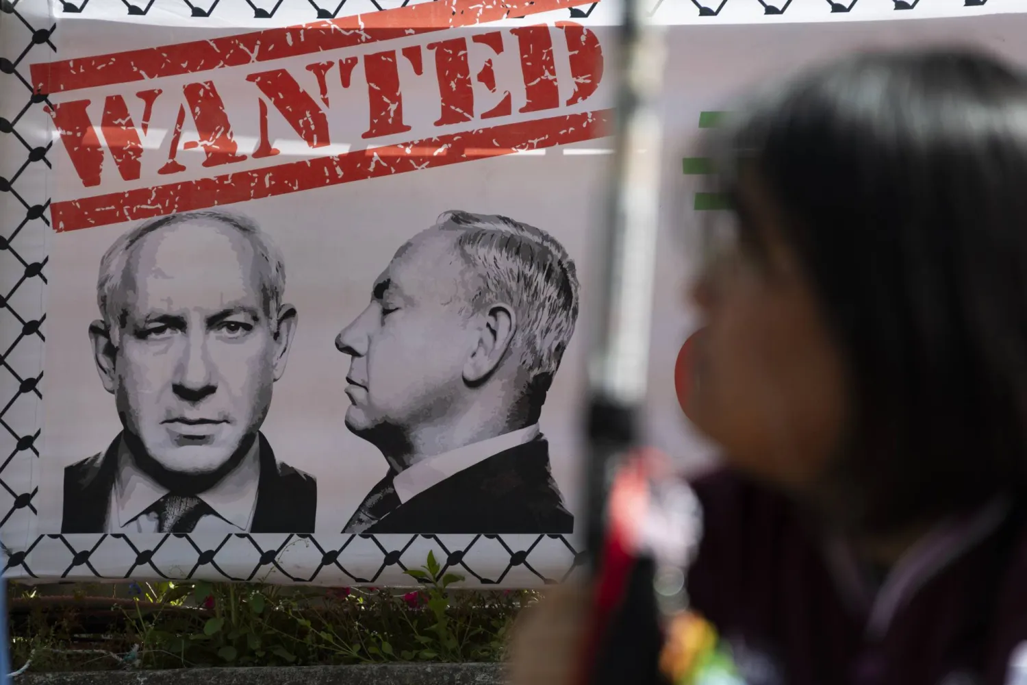 لافتة تحمل صورة لرئيس الوزراء الإسرائيلي بنيامين نتنياهو خلال احتجاجات على الضربات الأميركية الإسرائيلية على إيران في سيول (إ.ب.أ) 