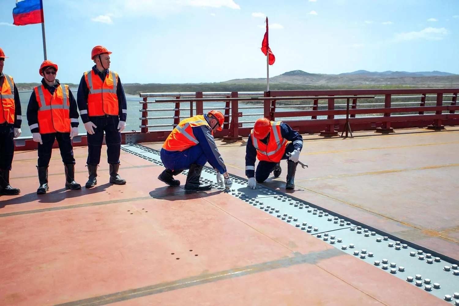 This handout image released by the Russian Transport Ministry on April 21, 2026, shows a ceremony marking the connection of the two sides of the new Russia-North Korea road bridge over the Tumen River, set to open this summer. (Handout / Russian Transport Ministry / AFP) 