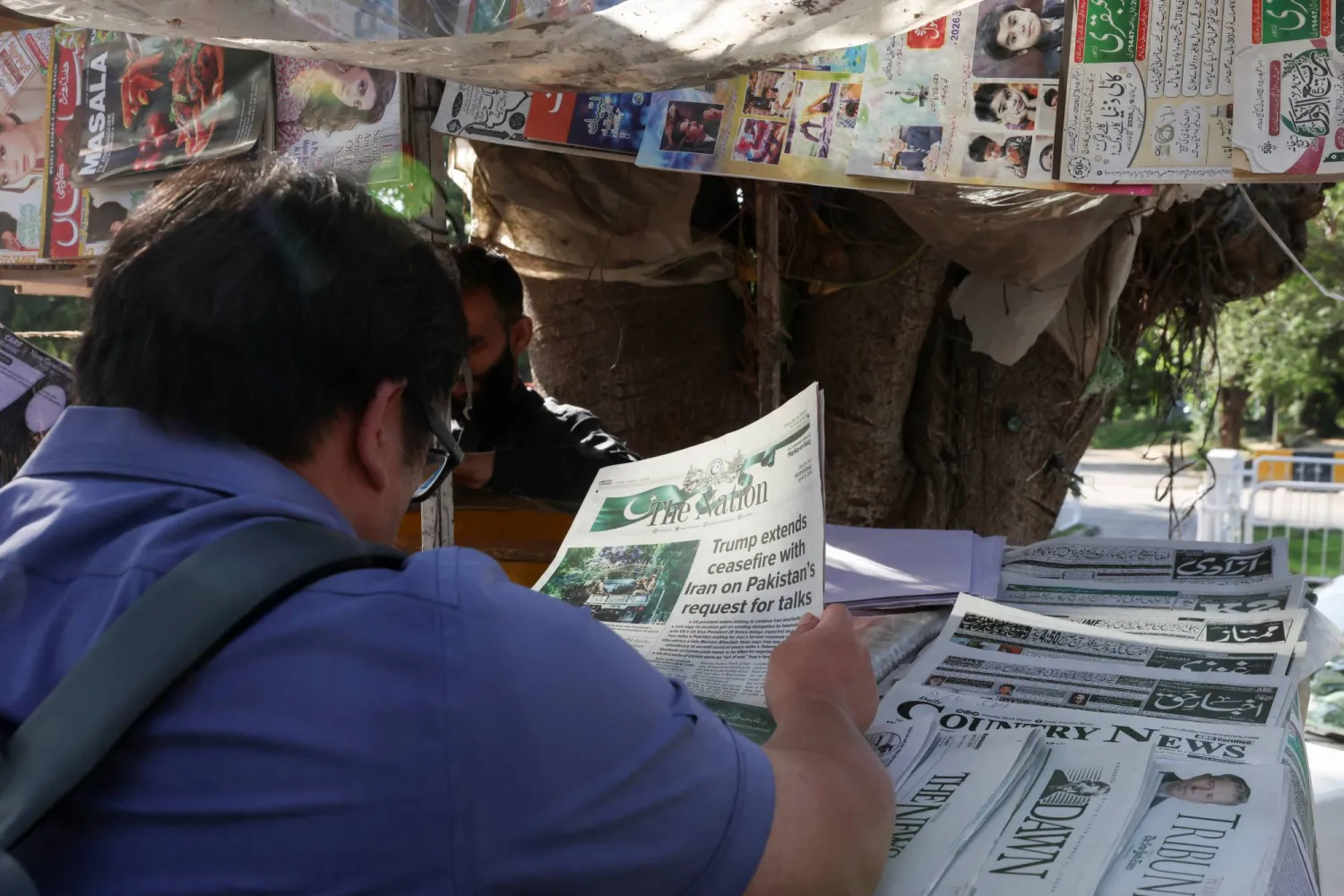 A person reads a newspaper, after US President Donald Trump said he would indefinitely extend the ceasefire with Iran, as Pakistan prepares to host the US and Iran for the second phase of peace talks in Islamabad, Pakistan April 22, 2026. REUTERS/Akhtar Soomro