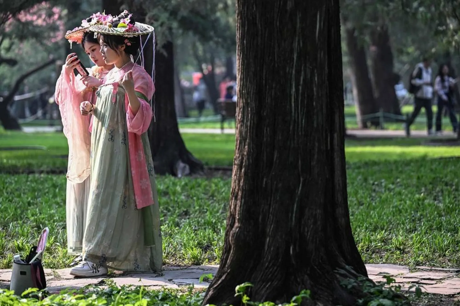  Women dressed in imperial outfits visit the Zhongshan Park during spring season in Beijing on April 18, 2026. (AFP) 