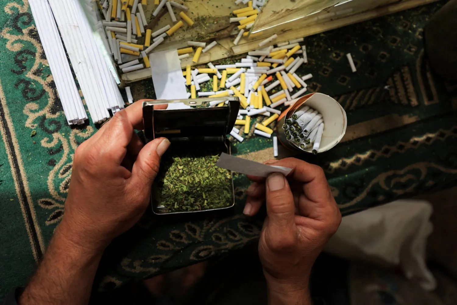 بائع فلسطيني يبيع سجائر مصنوعة من أوراق الملوخية المجففة كبديل للتبغ (رويترز)