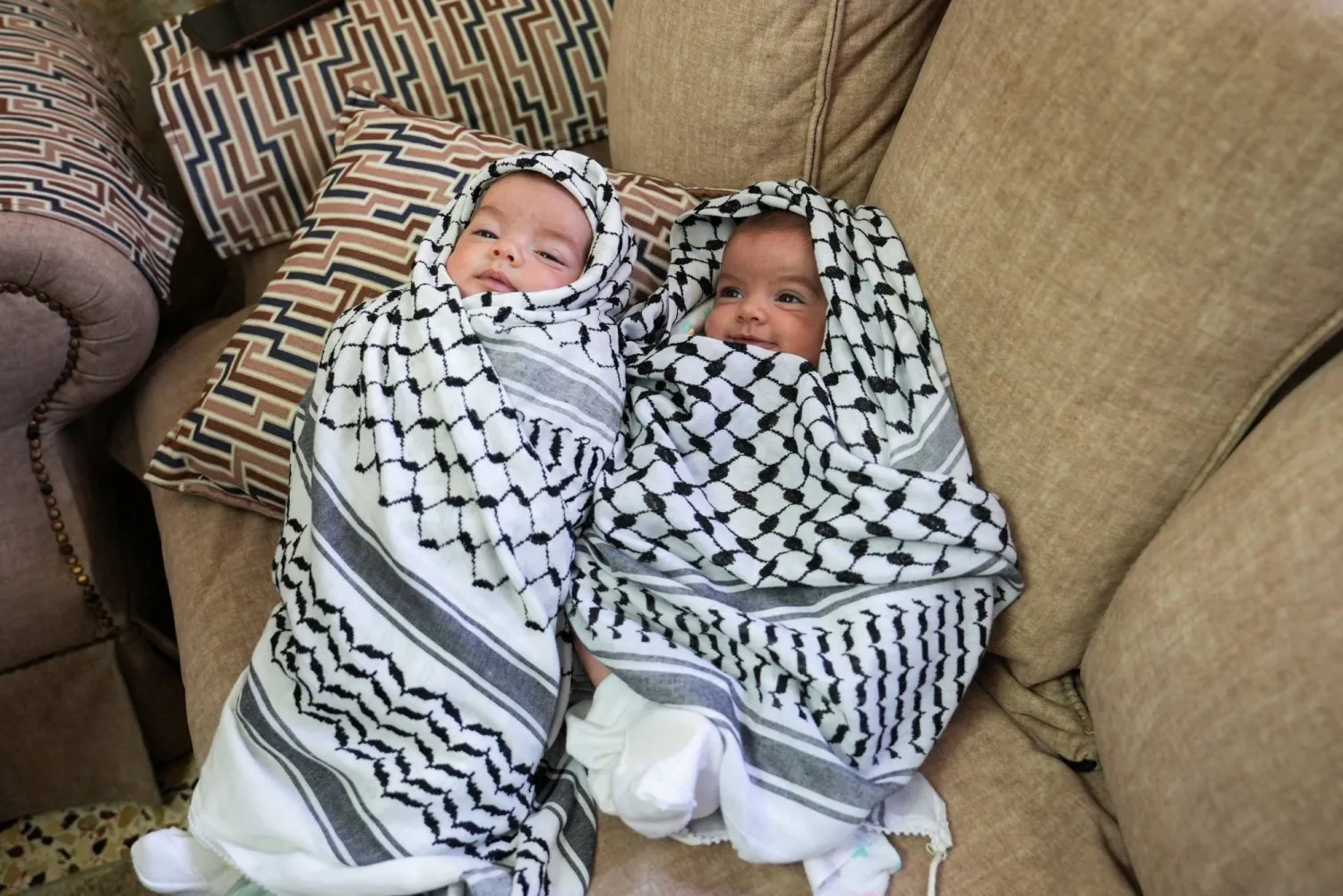 ابنتا الشاب الفلسطيني عودة عواودة (25 عاماً) الذي قُتل في هجوم استيطاني إسرائيلي خلال جنازته قرب رام الله في الضفة الغربية الخميس (رويترز)