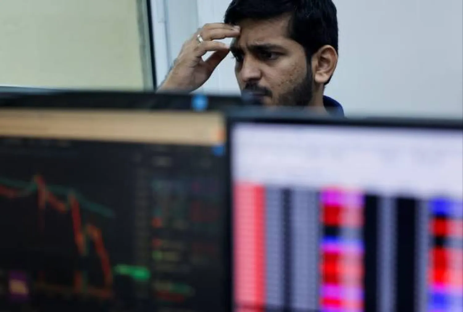 متداول أسهم أثناء مزاولته عمله داخل شركة وساطة مالية في مومباي (رويترز)