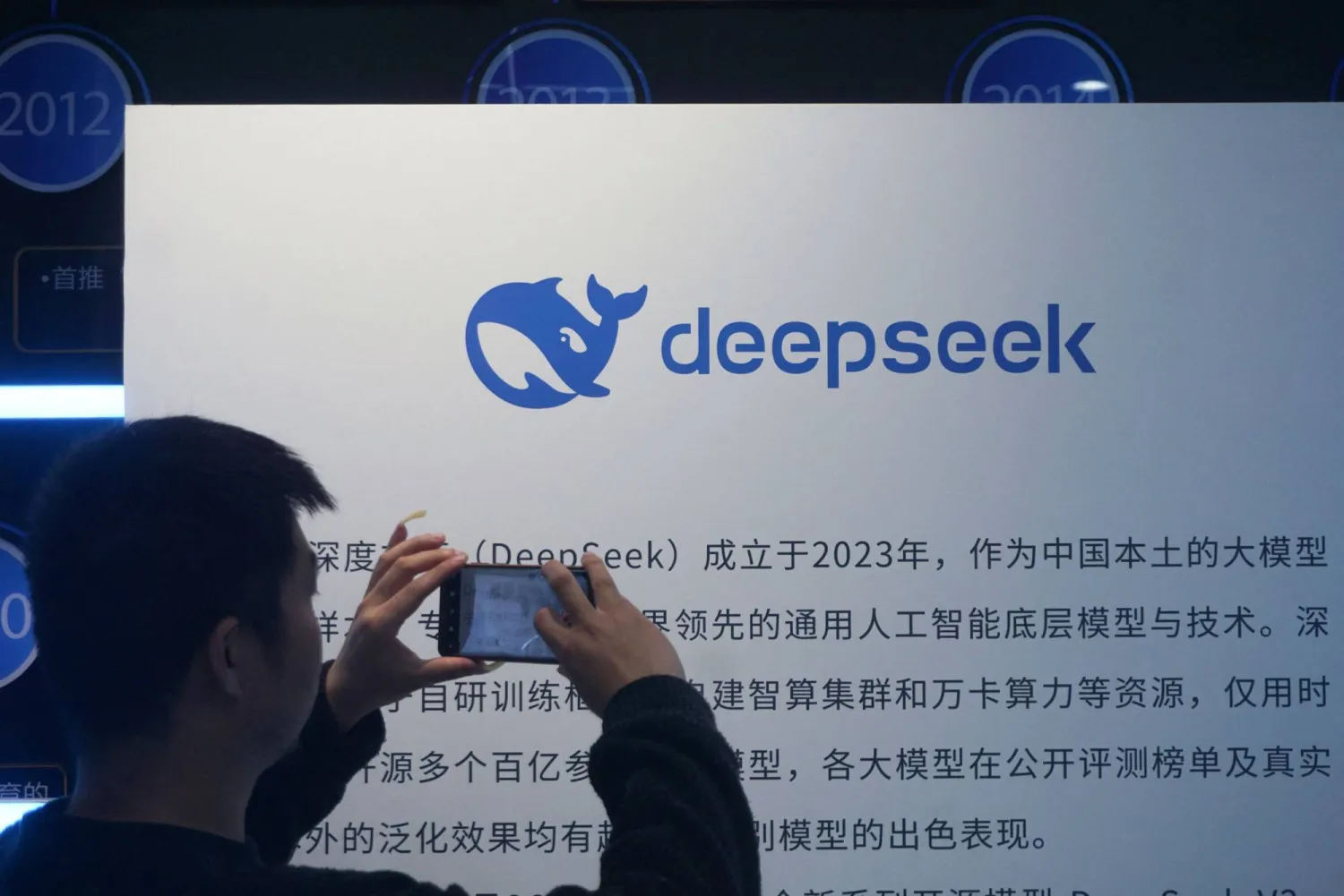 A man takes photos of a DeepSeek display at a shopping mall in Hangzhou, in China's eastern Zhejiang province on April 23, 2026. (Photo by CN-STR / AFP) 