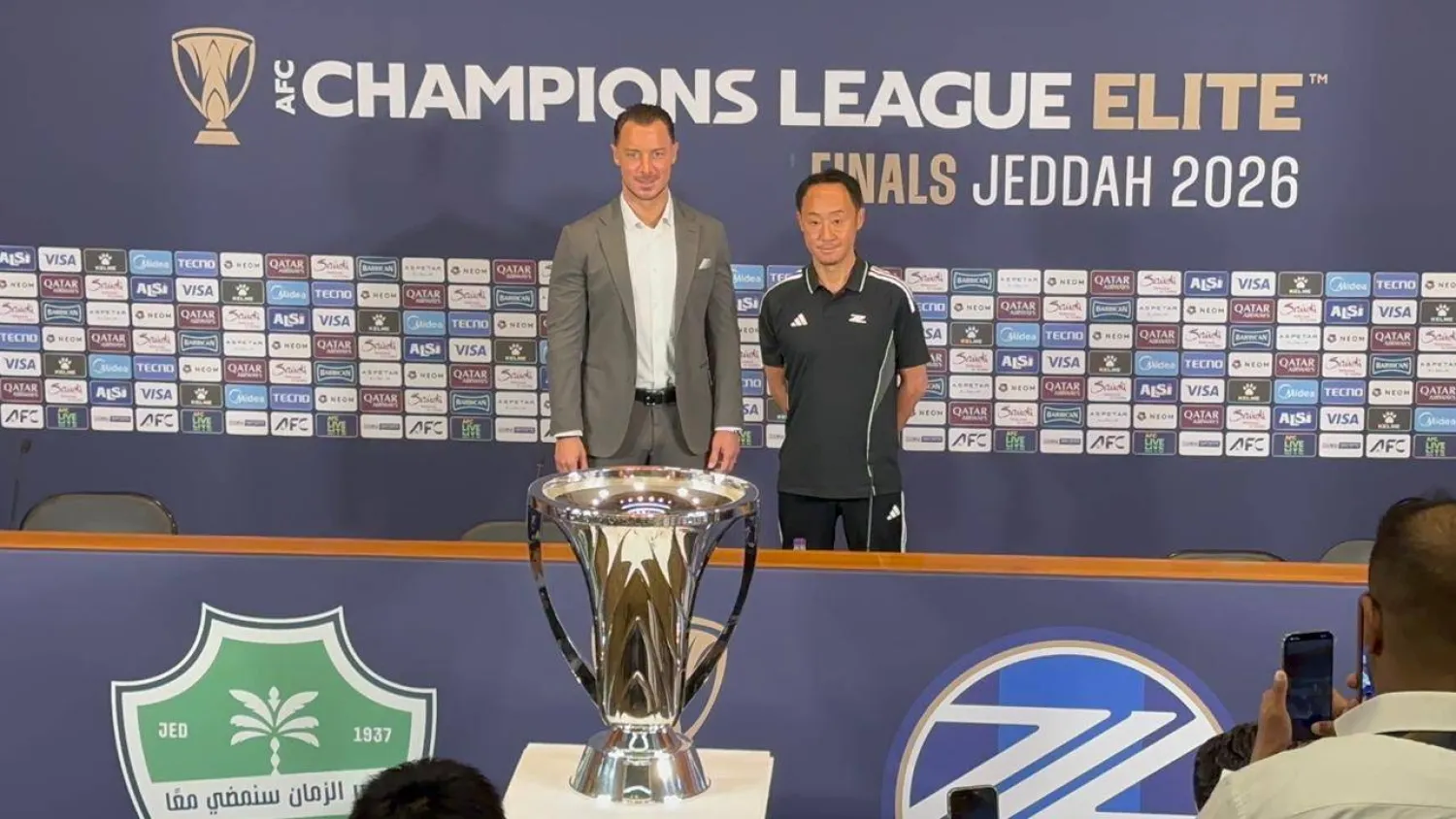 الياباني غو كورودا مدرب فريق ماتشيدا بجوار يايسله وكأس البطولة (الشرق الأوسط) 