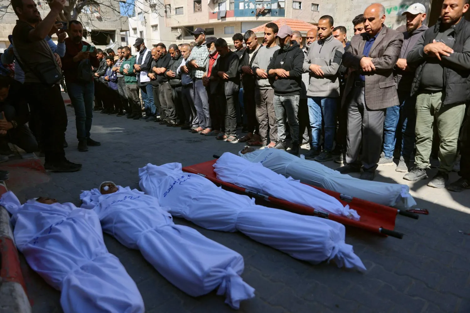 فلسطينيون يشيعون قتلى سقطوا في هجوم إسرائيلي أمام مستشفى الشفاء بمدينة غزة الخميس (أ.ف.ب)