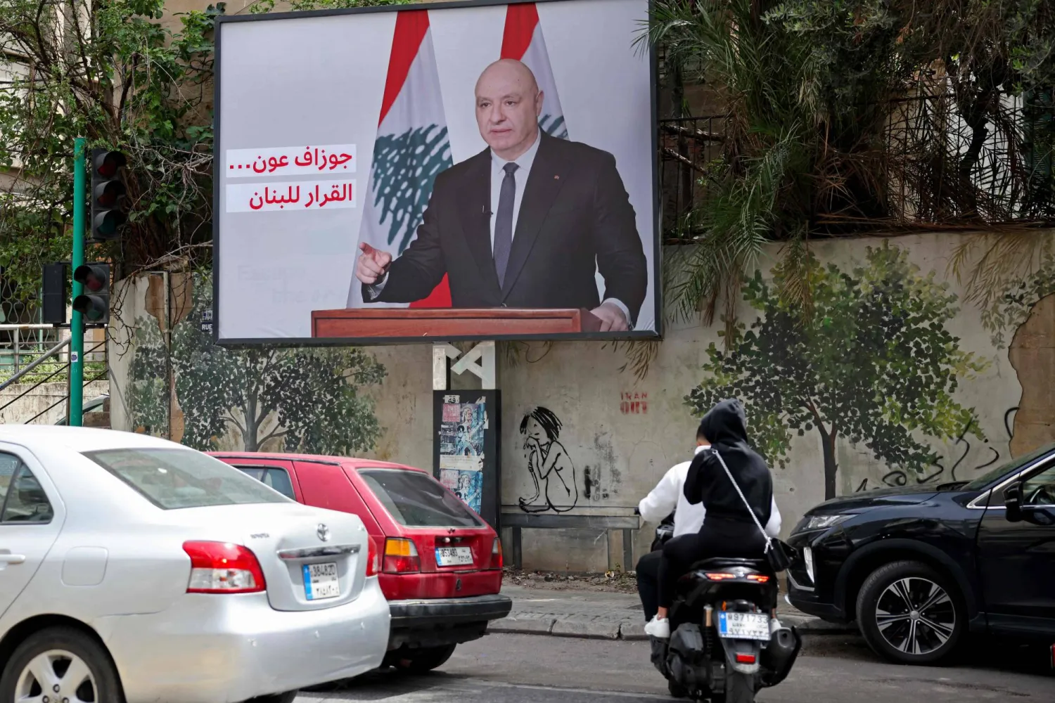 شعار مؤيد لقرارات الرئيس اللبناني جوزيف عون مكتوب على صورة عملاقة له في أحد شوارع بيروت (أ.ف.ب)