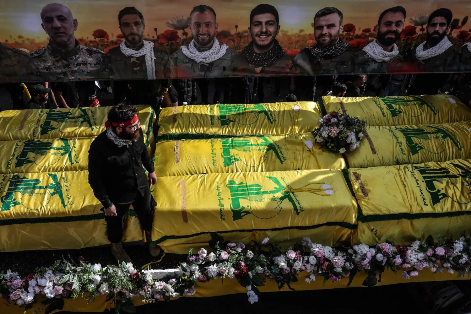Coffins sit on a trailer beneath portraits of Hezbollah fighters killed before a 10-day ceasefire was agreed between the Iran-backed militant group and Israel during a mass funeral procession in the southern village of Kfar Sir on April 21, 2026. (AFP)
