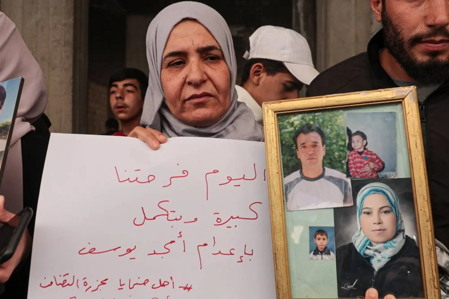 A woman holds photos of her relatives who were killed in the Tadamon massacre during a celebration after the arrest of Amjad Youssef, the main perpetrator in the massacre, in the Tadamon neighborhood, Damascus, Syria, 24 April 2026. (EPA) 