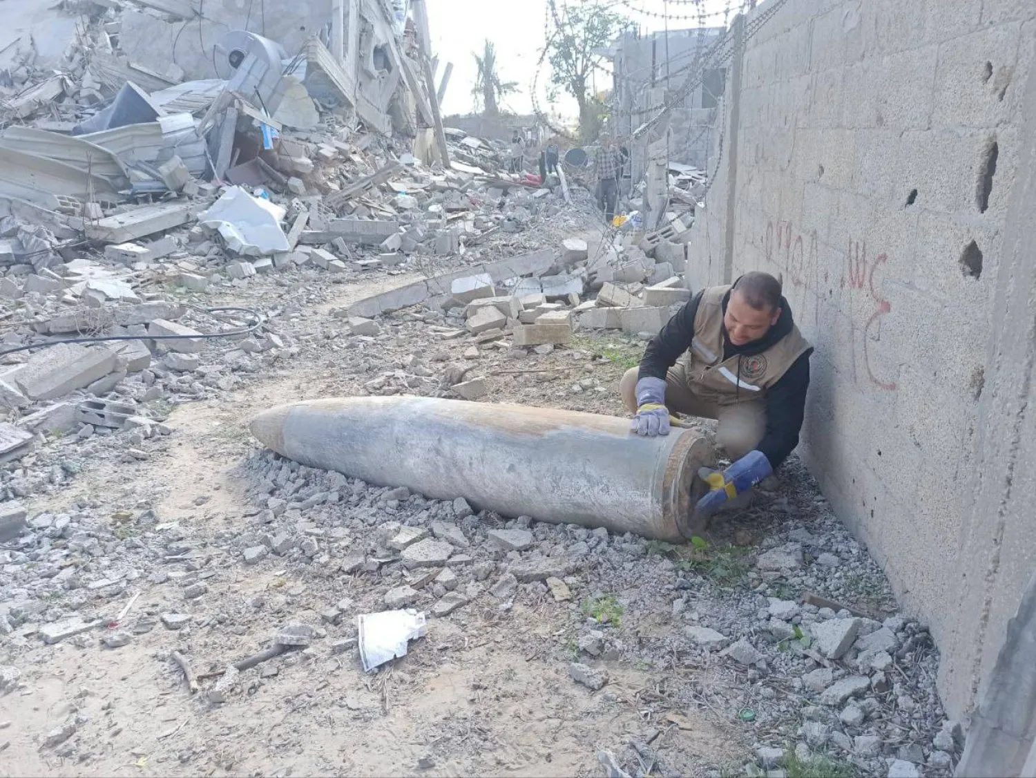 أحد عناصر هندسة المتفجرات التابعة لشرطة غزة يتعامل مع قذيفة غير منفجرة (الشرطة الفلسطينية)