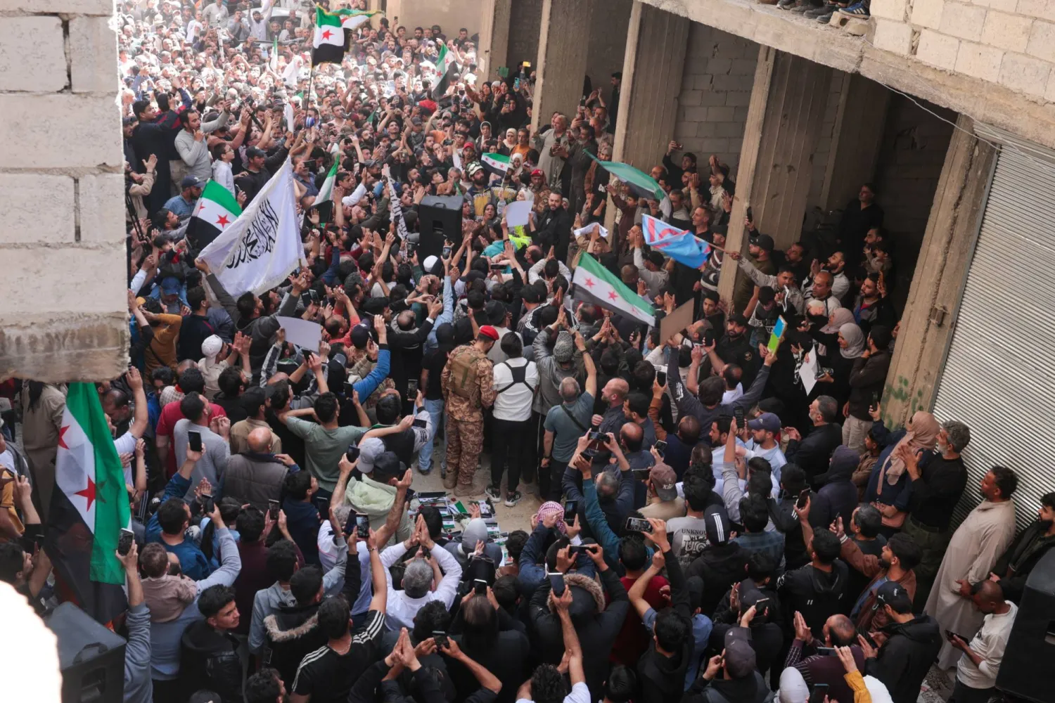 سوريون يحتفلون بالقبض على المتهم بارتكاب «مجزرة التضامن» في حي التضامن بدمشق الجمعة (إ.ب.أ)