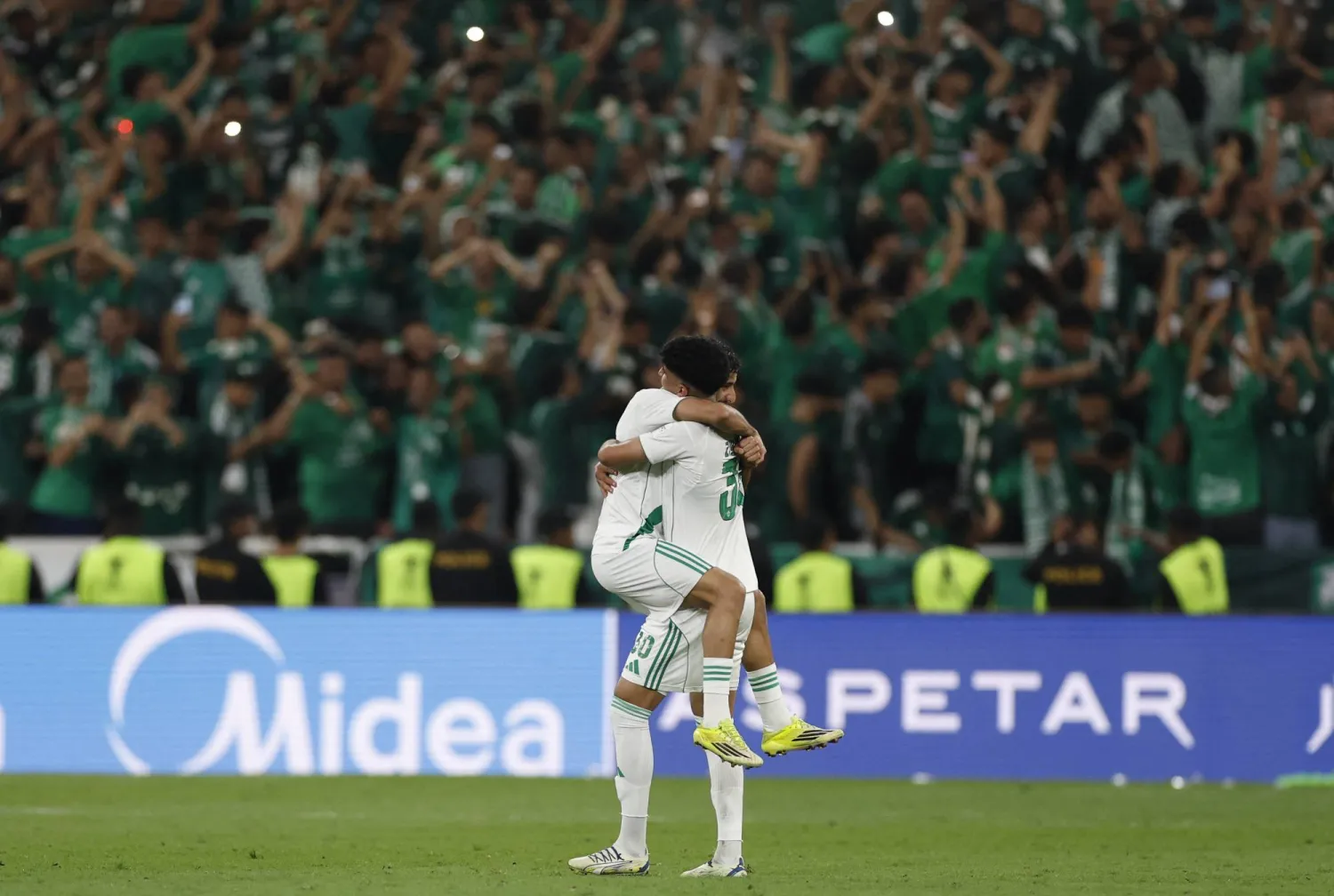 لاعبا الأهلي يحتفلان أمام جماهيرهما باللقب الآسيوي (رويترز)