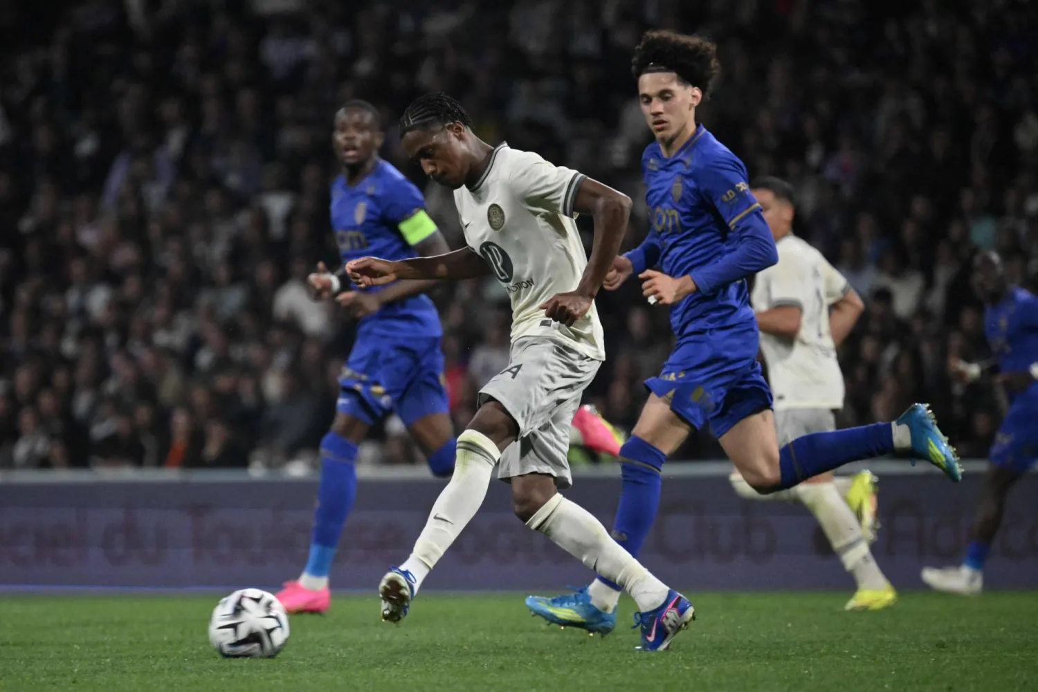 لاعب وسط تولوز السنغالي بابي ديمبا ديوب يمرر الكرة أمام لاعب وسط موناكو ماغنيس أكليوش (أ.ف.ب)