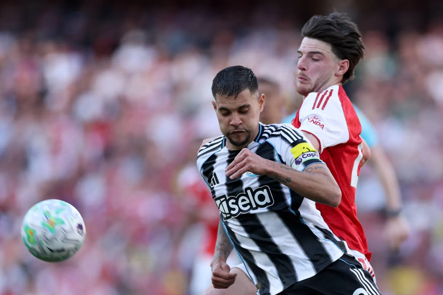 لاعب نيوكاسل يونايتد برونو غيماريش يتنافس على الكرة مع لاعب أرسنال ديكلان رايس (أ.ب)