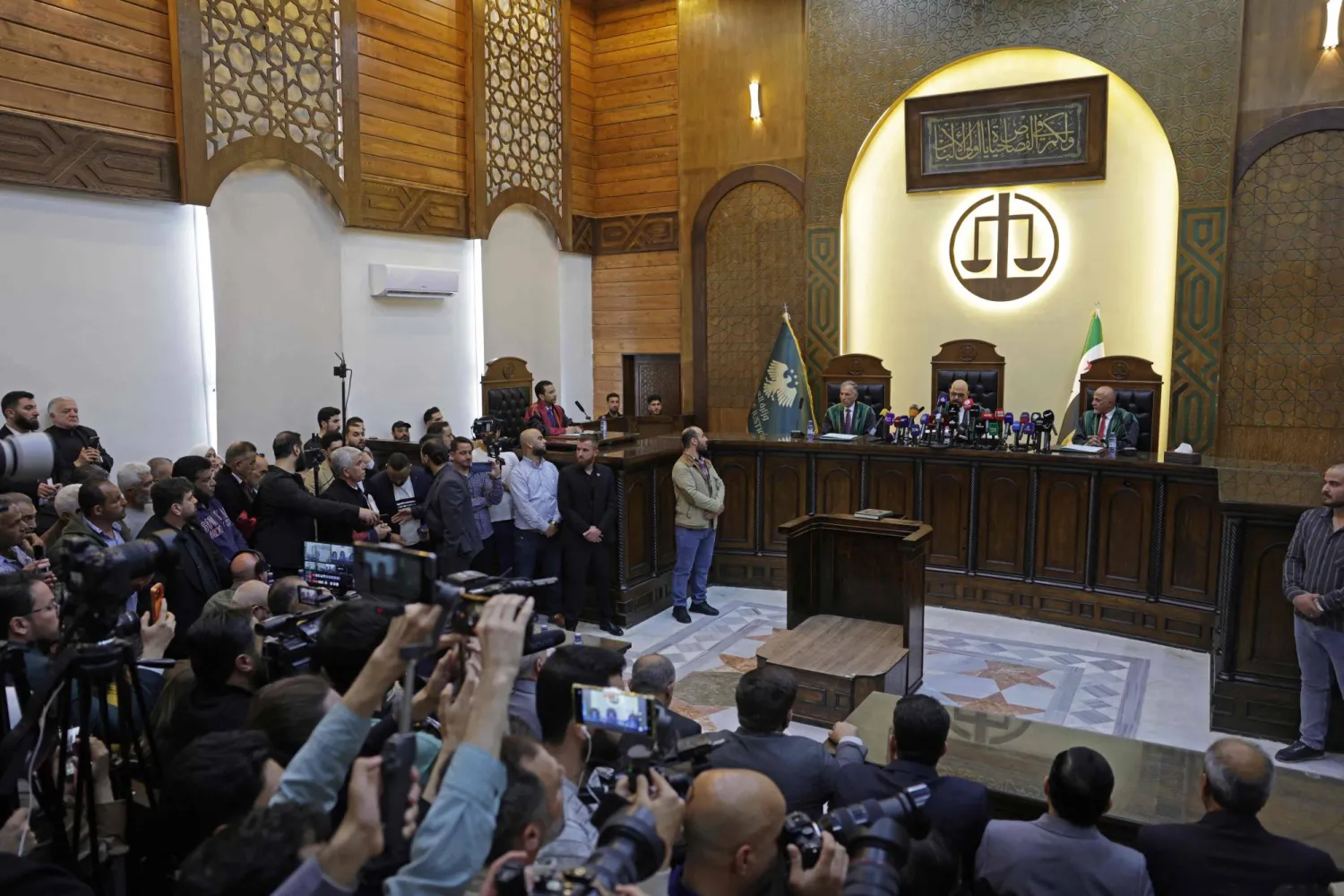 مسؤولون قضائيون وجمهور في الجلسة الأولى لمحاكمة رموز نظام الأسد في قصر العدل بدمشق الأحد (أ.ف.ب)