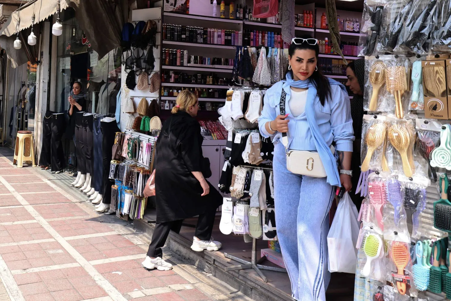 امرأة تغادر متجراً بعد التسوق في طهران يوم 20 أبريل 2026 (أ.ف.ب)