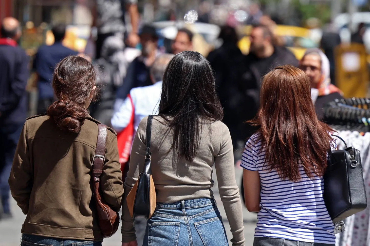 Iranian women walk along a busy street in Tehran on April 25, 2026. (AFP)