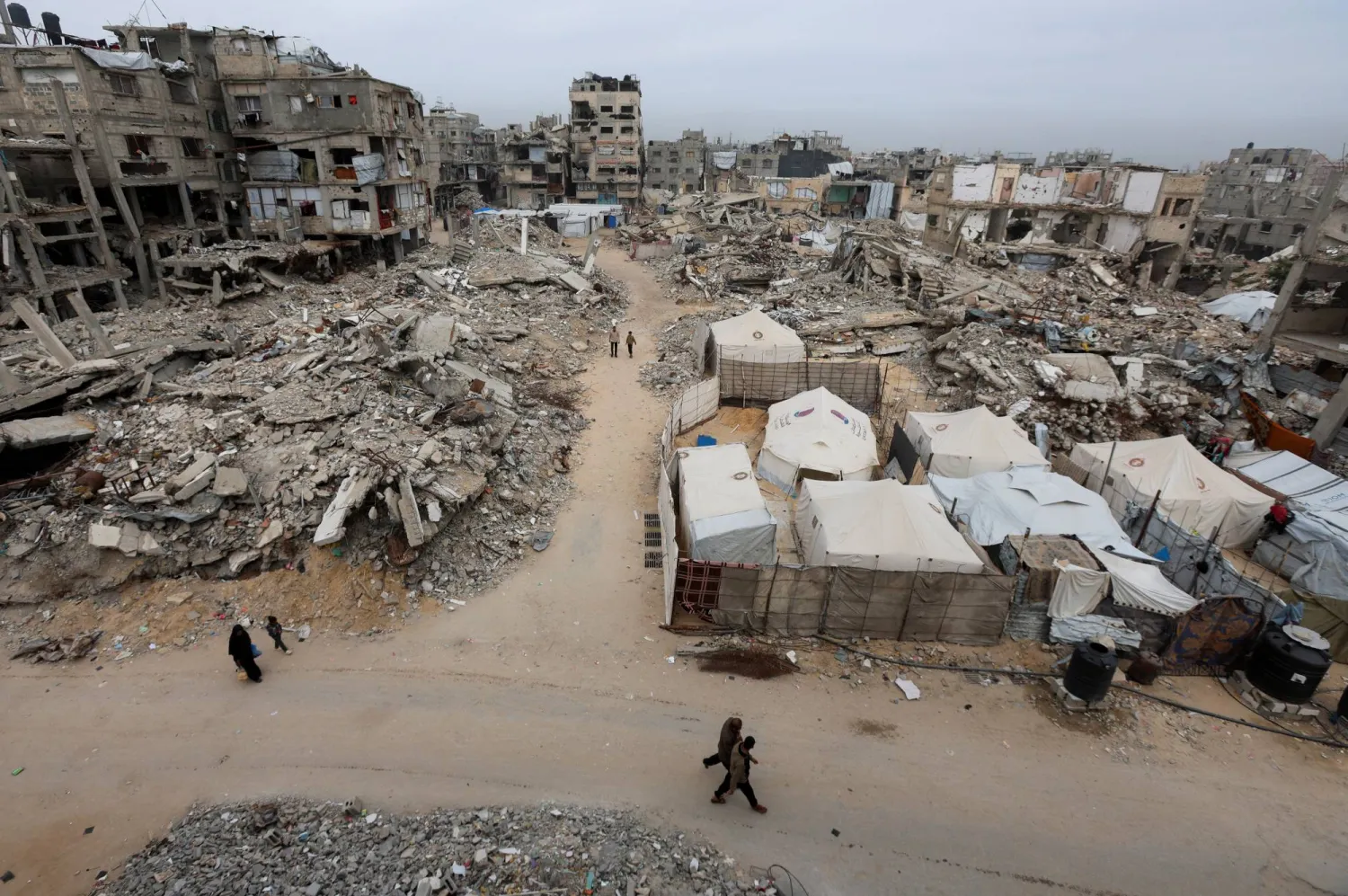  Palestinians walk past the rubble of residential buildings destroyed during the two-year Israeli offensive, in Khan Younis, southern Gaza Strip, April 15, 2026. (Reuters)