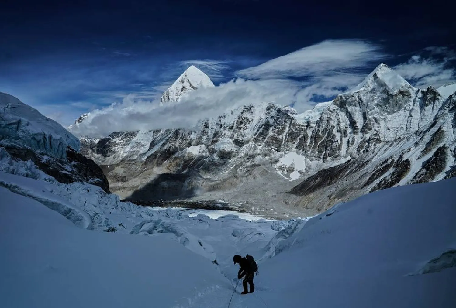 Mount Pumori, center left, looms in the background as a mountaineer negotiates Khumbu Icefall to descend to Everest Base Camp, in Nepal, May 4, 2025. (AP)