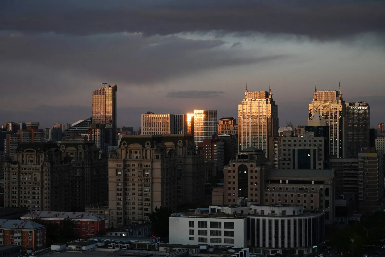 Light reflects off buildings at sunset in Beijing on April 27, 2026. (AFP)
