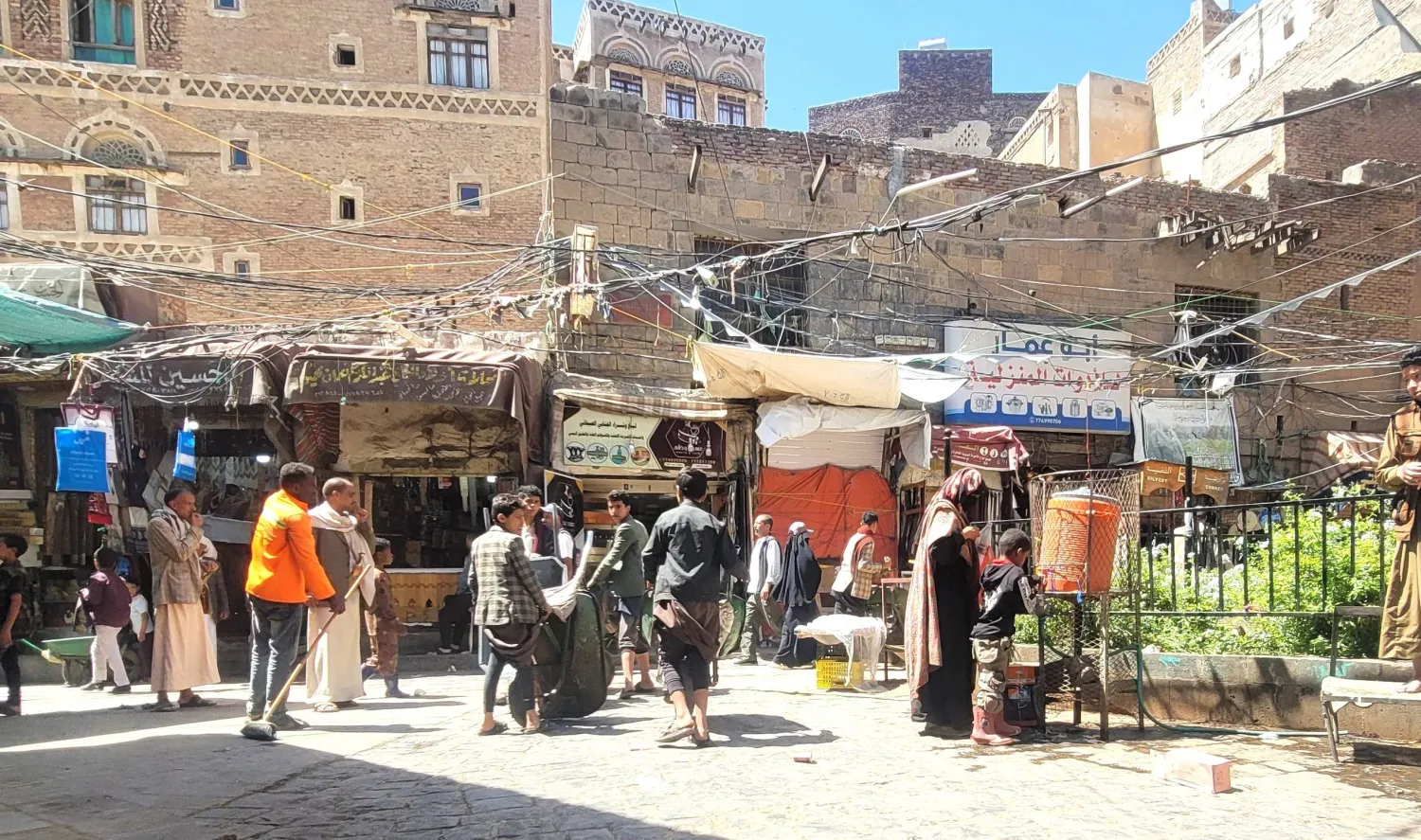 عاملون يمنيون برفقة عربات يدوية بانتظار الزبائن في سوق شعبية بصنعاء (الشرق الأوسط)