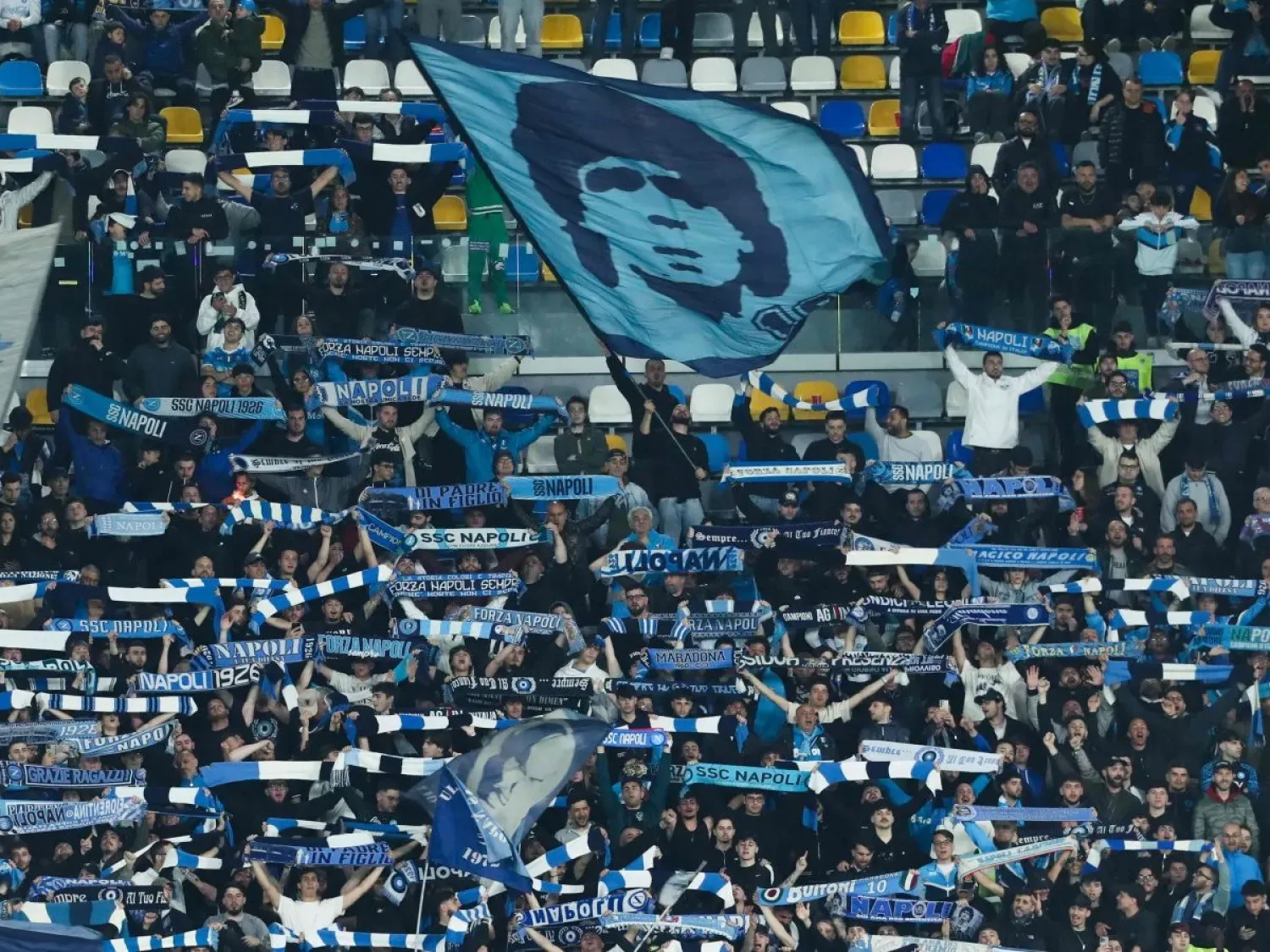 Napoli taraftarları, İtalya Ligi’nde oynanan bir maç sırasında Arjantinli efsane Diego Armando Maradona’nın fotoğrafının işlendiği bayrağı sallıyor. (AFP)