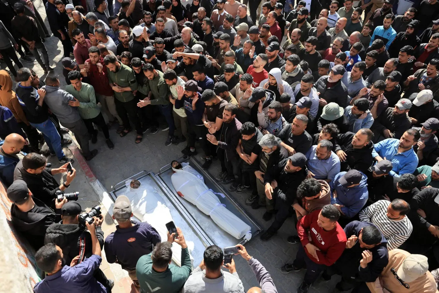 Gazze kentindeki Şifa Hastanesi’nde, sağlık görevlilerine göre İsrail hava saldırısında hayatını kaybeden Filistinlilerin cenazesine katılan yas tutanlar (Reuters)