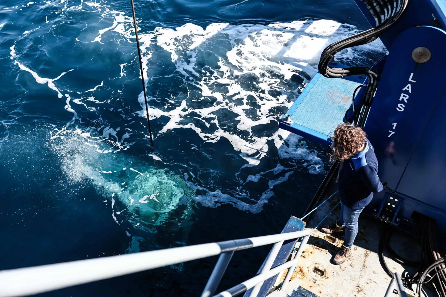 Marine Sadania, a maritime archaeologist in charge of scientific and heritage management for the PACA Coastal Observatory, observes the “ROV C 4000,” a remotely operated vehicle manufactured by the French company LD Travocean and designed for seabed exploration,  during its launch aboard the Jason (BSAA), chartered for an archaeological mission on the wreck of the CAMARAT 4 off the coast of Ramatuel, in southeastern France on April 7, 2026. (Photo by Thibaud MORITZ / AFP)