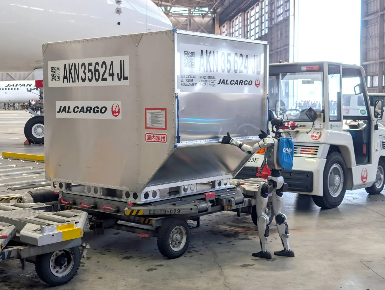 روبوت بشري الشكل يدفع حاوية خلال عرض إعلامي في مطار هانيدا بطوكيو (إ.ب.أ)