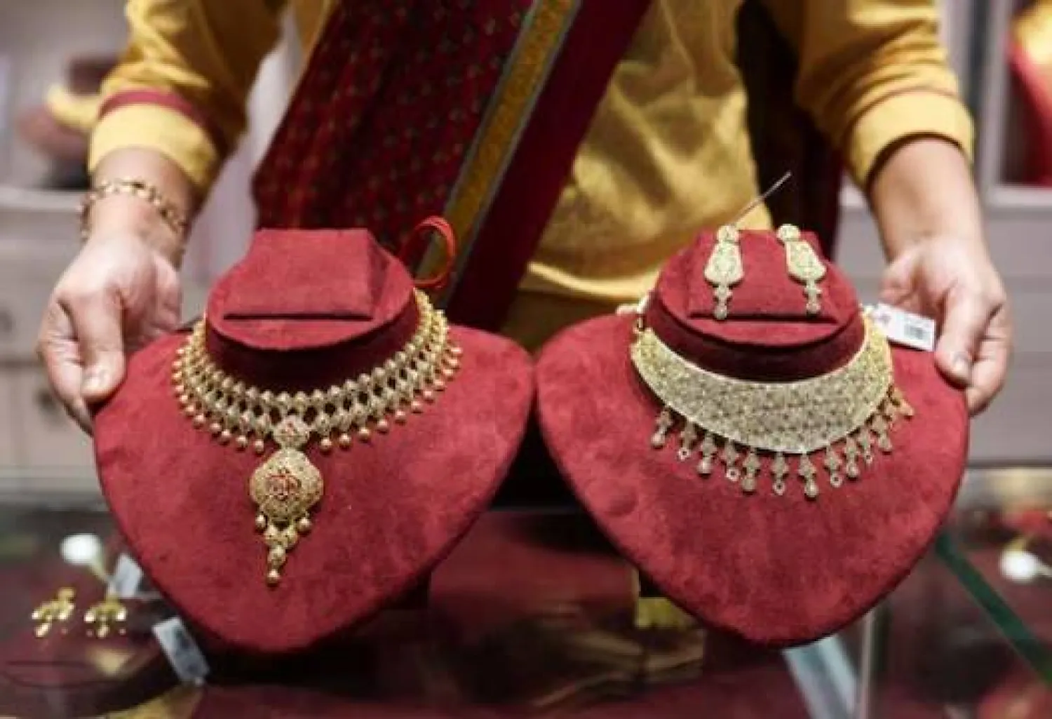 بائعة قلائد ذهبية داخل صالة عرض شركة «سينكو غولد آند دايموندز» للمجوهرات في كولكاتا بالهند (رويترز)