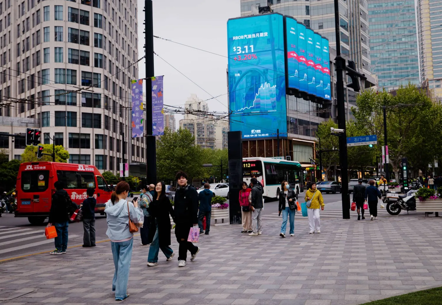 شاشة عملاقة تعرض حركة الأسهم بأحد ميادين مدينة شنغهاي الصينية (إ.ب.أ)