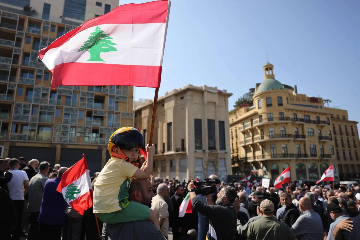 A child waves a Lebanese flag while residents, mukhtars, and inhabitants of the devastated southern Lebanese border villages protest against the destruction of their villages and being prevented from returning by order of the Israeli army, at Martyrs’ Square in central Beirut on April 30, 2026. (AFP)