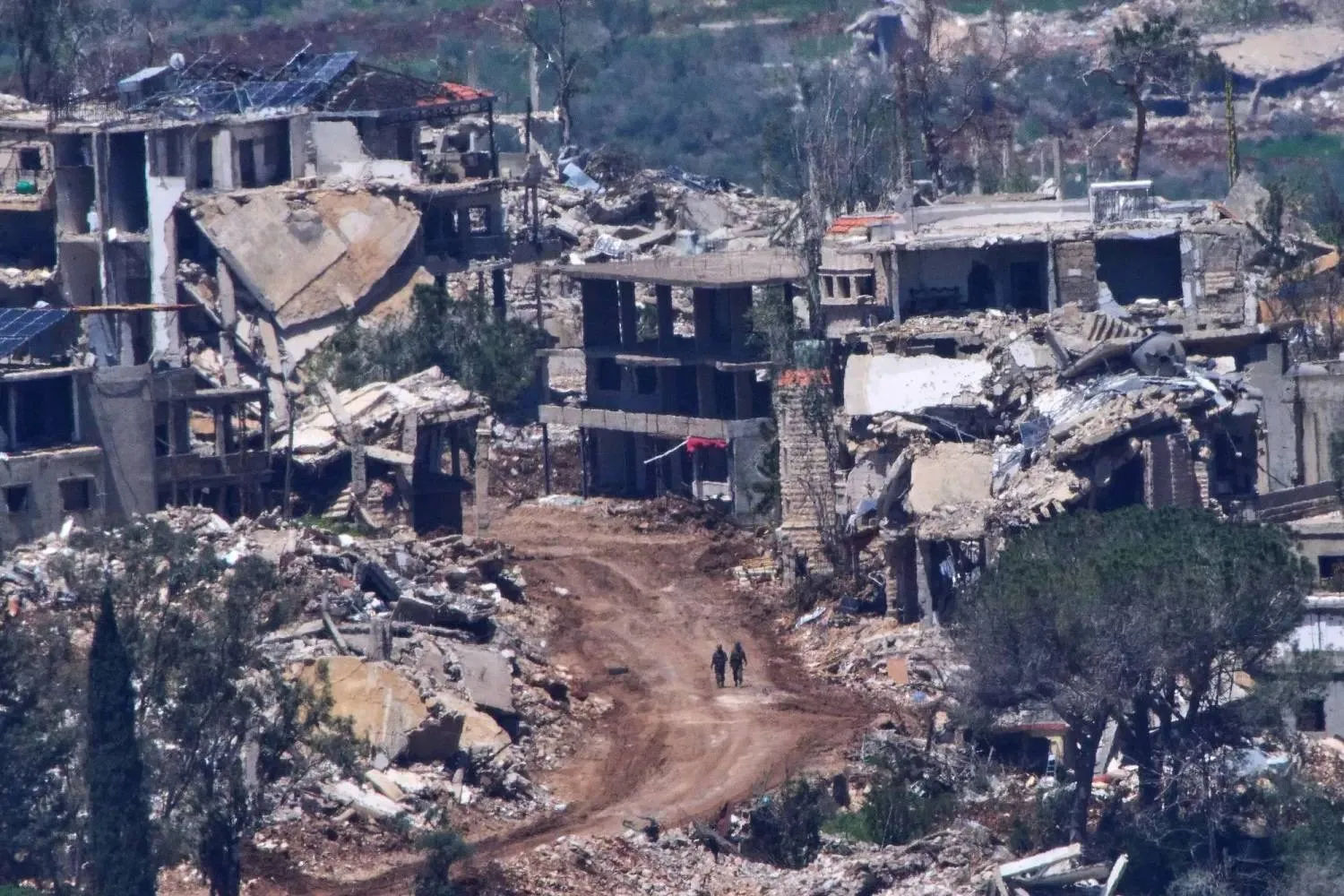 Two Israeli soldiers walk through rubble in southern Lebanon (AP)

