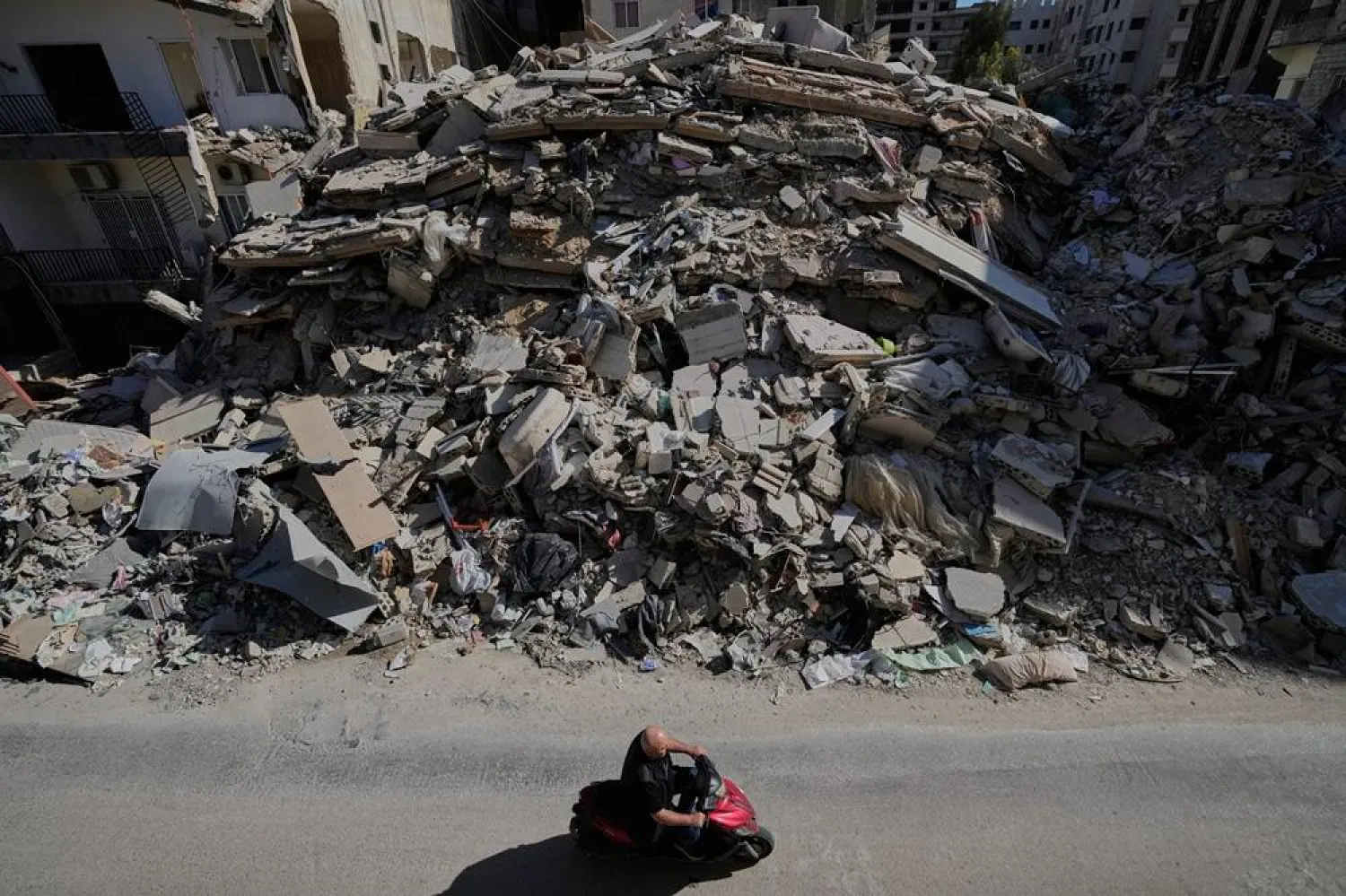  A man passes on his scooter in front of a destroyed building that was hit few weeks ago by an Israeli airstrike, in the southern port city of Tyre, Lebanon, Thursday, April 30, 2026. (AP) 